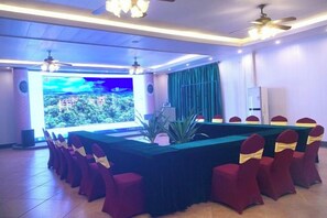 A conference room with a long table, red chairs, and a large screen. - Nankunshan Shihe Wonder Resort Villa (Longmen)