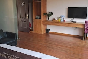 A hotel room with a bed, a wooden desk, a television, and a door. - Nankunshan Shihe Wonder Resort Villa (Longmen)
