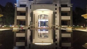 A hotel entrance with a reflective pool in front, a central archway, and a well-lit interior visible through the archway. - Nankunshan Shihe Wonder Resort Villa (Longmen)