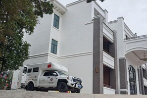 A white building with a large entrance and a white truck parked in front. - Nankunshan Shihe Wonder Resort Villa (Longmen)