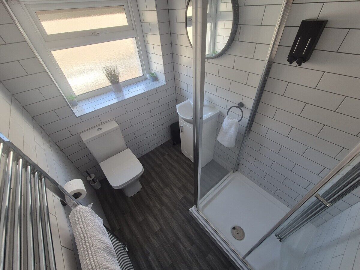 A modern bathroom with a toilet, sink, and glass-enclosed shower.