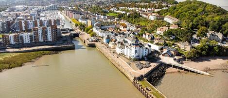 A coastal town with a river, buildings, and a bridge.