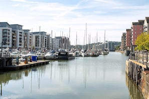 A marina with multiple boats docked, a waterway, and buildings on both sides. - Seaview 2-bed With Private Parking, Portishead (Bristol)