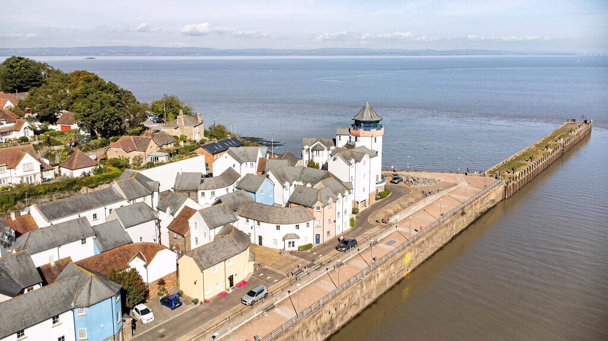 A coastal town with a prominent tower, narrow streets, and a long waterfront promenade.