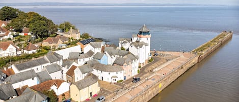 A coastal town with a prominent tower, narrow streets, and a long waterfront promenade.