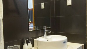 A modern bathroom with a white sink, a mirror, and a towel rack. - BEAR HOTEL & HOMESTAY 2 (Da Nang)
