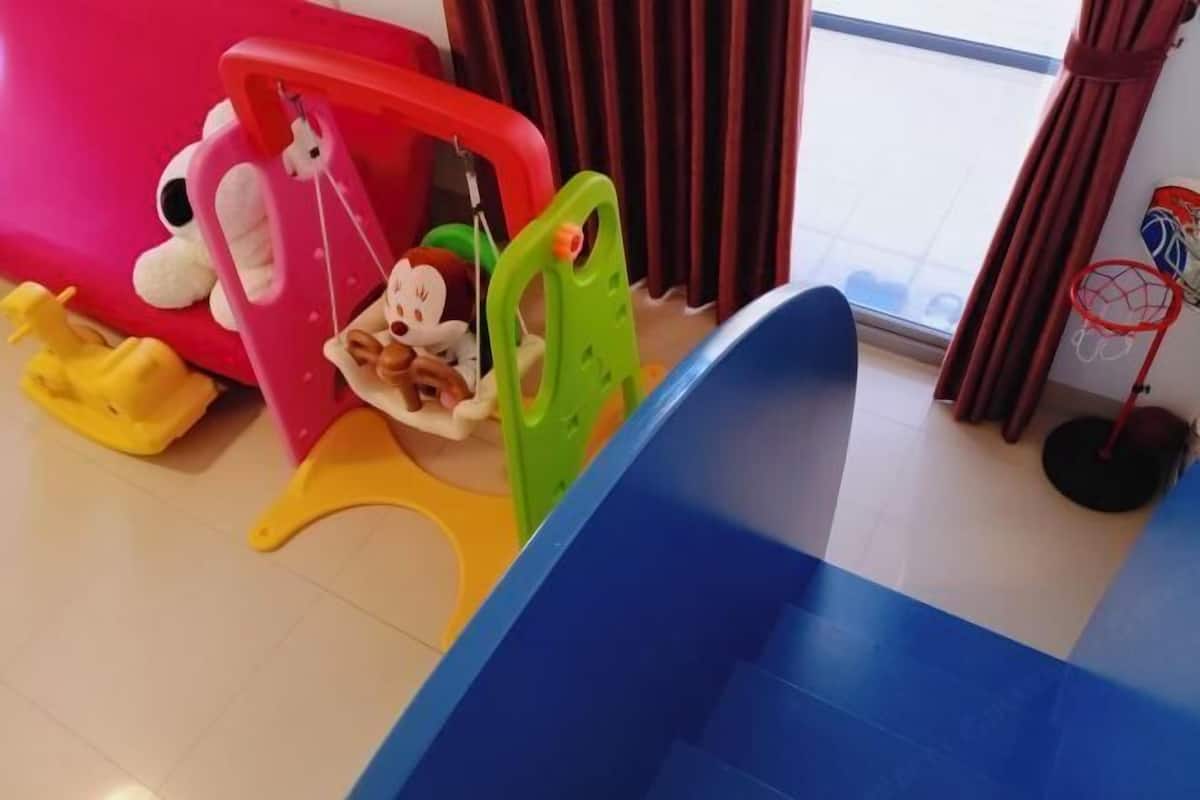 A children's play area with a slide, a toy Mickey Mouse, and a basketball hoop.