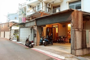 A building with a storefront, a motorcycle parked outside, and a bicycle in front. - One of seven BnB (Hualien)