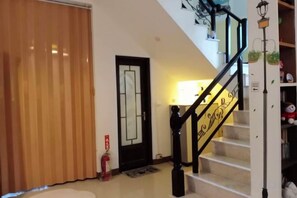A staircase with a black railing, a door with a mirror, and a lamp post. - One of seven BnB (Hualien)