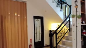 A staircase with a black handrail and a white wall with a door. - One of seven BnB (Hualien)