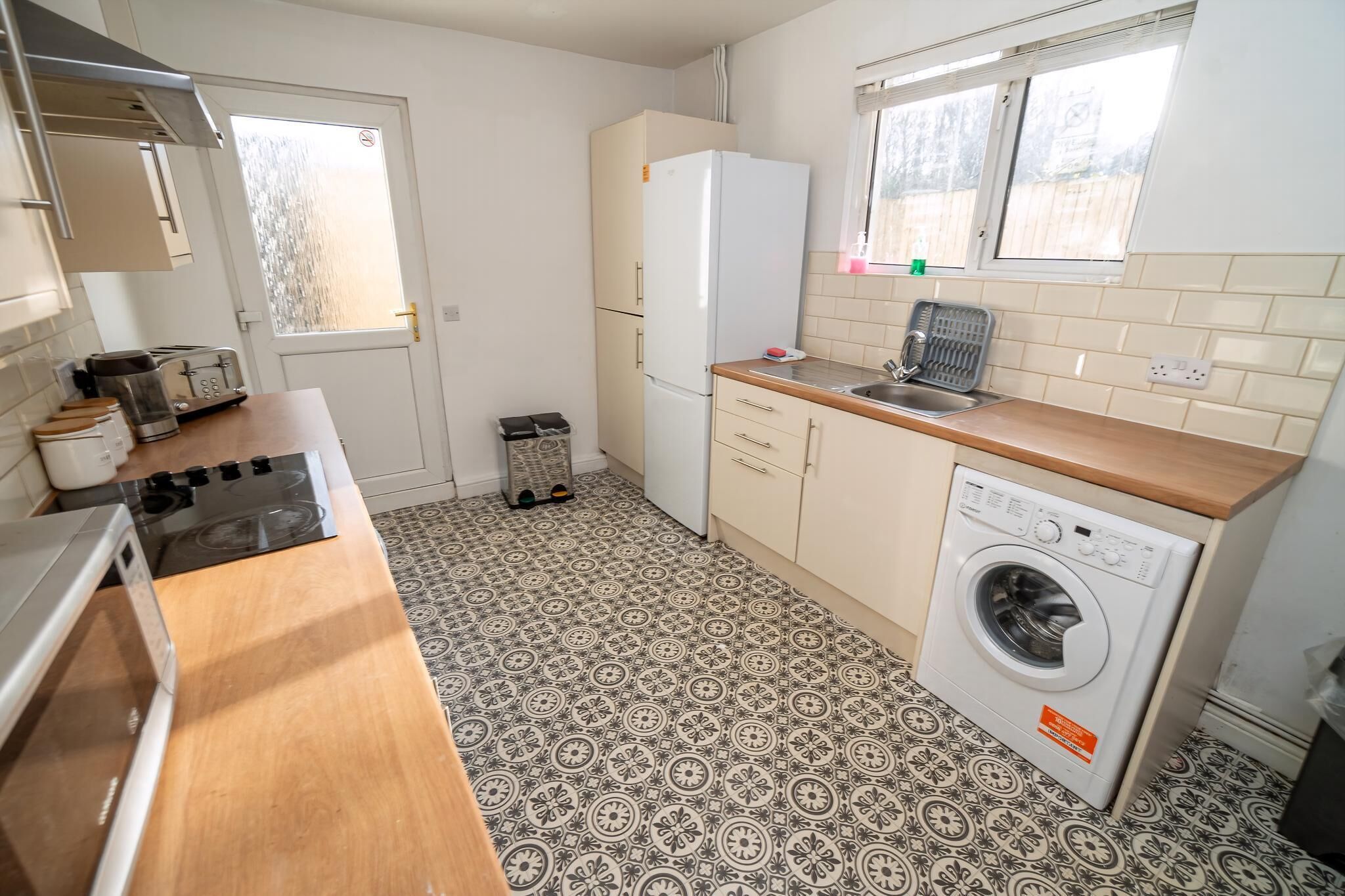 Une cuisine compacte équipée d’une cuisinière, d’un four à micro-ondes, d’un grille-pain, d’un réfrigérateur et d’un lave-linge.