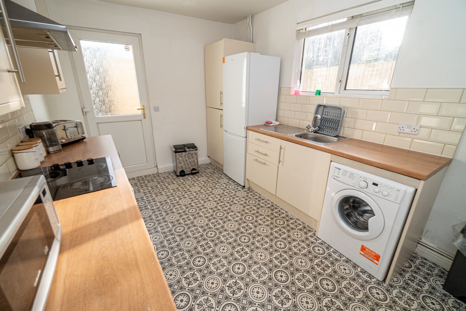 Une cuisine compacte équipée d’une cuisinière, d’un grille-pain, d’un réfrigérateur et d’un lave-linge.