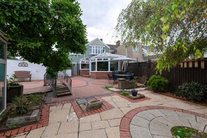 A patio area with a gazebo, outdoor seating, and a brick pathway. - The Swansea Homestay Spacious 4-bed Retreat (Swansea)