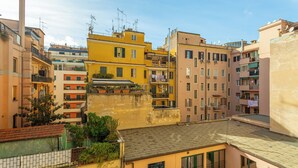 A multi-story residential building with balconies, a visible rooftop garden, and a clear sky. - Dea Roma (Rome)