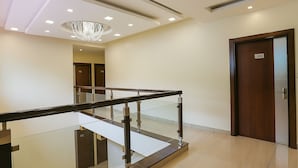 A modern hotel lobby with a glass railing, a chandelier, and a wooden door marked with the number 304. - Hotel Winter Line Inn Near St Francis Monastery (Mussoorie)