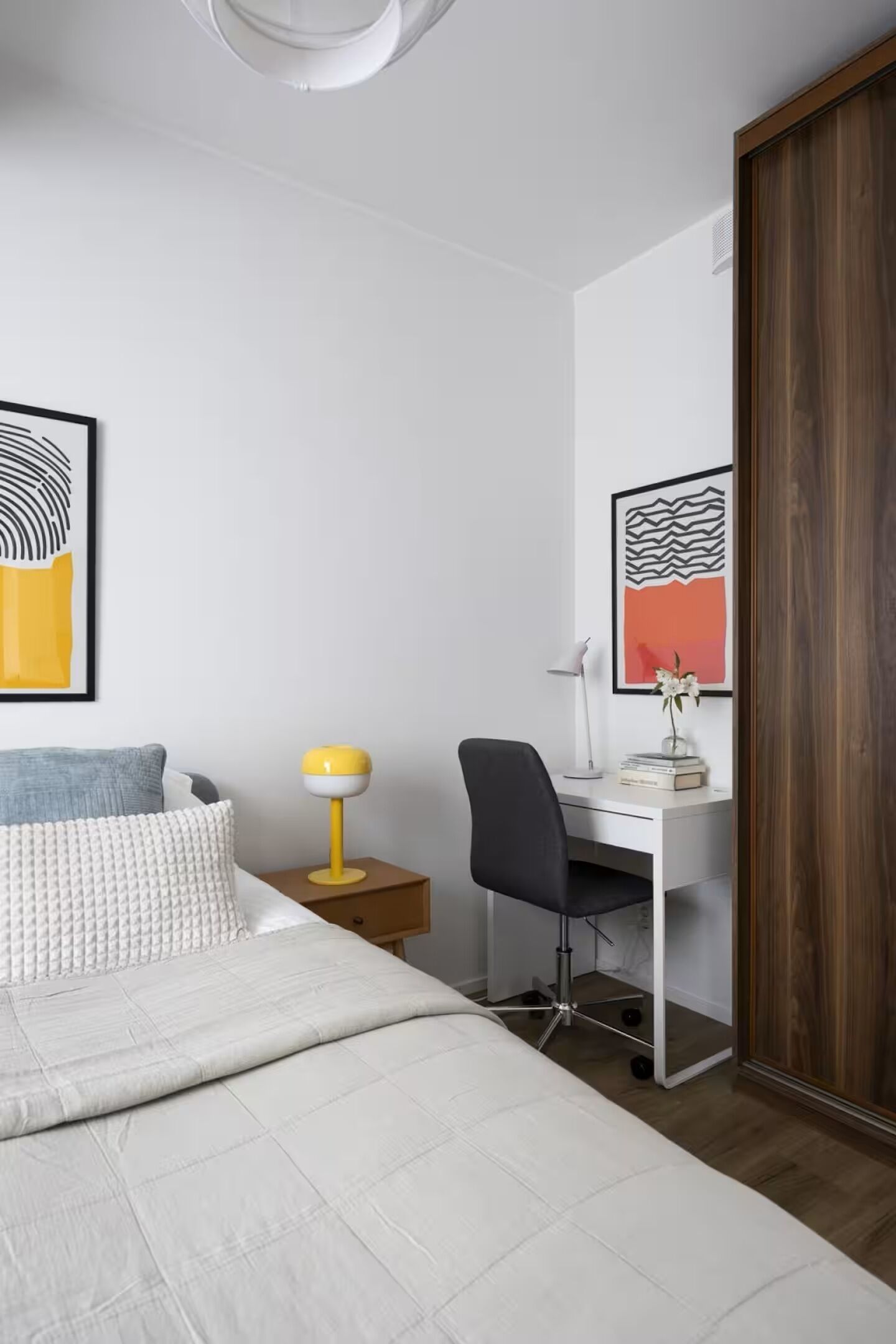 Un dormitorio con una cama, un escritorio y una silla.