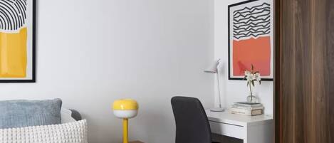Un dormitorio con una cama, un escritorio y una silla.