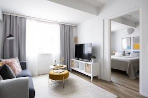 Superior-Apartment, Stadtblick | Wohnbereich | 50-Zoll-Smart-TV mit Kabelempfang