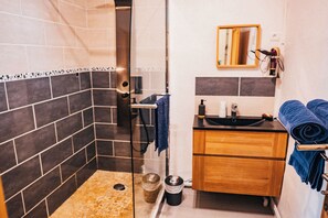 Comfort driepersoonskamer | Badkamer | Een douche, een haardroger, handdoeken, zeep