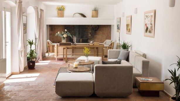 A spacious living room with a fireplace, comfortable seating, and decorative plants.