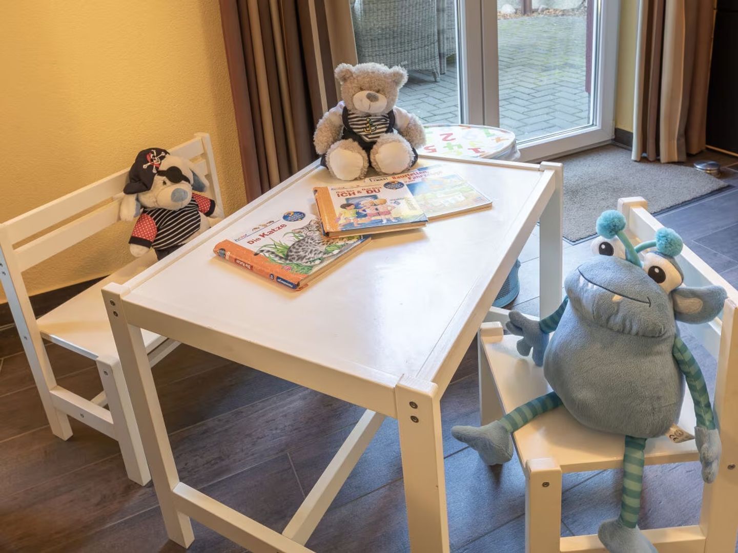 A child’s table with books and stuffed animals.