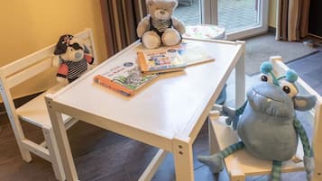 A child’s table with books and stuffed animals.