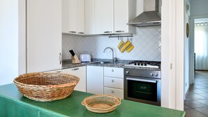 A kitchen with white cabinets, a stainless steel stove, and a green countertop.