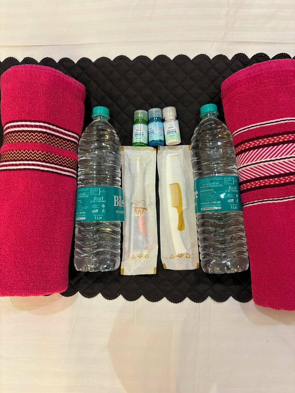A set of towels and bottles on a black surface.