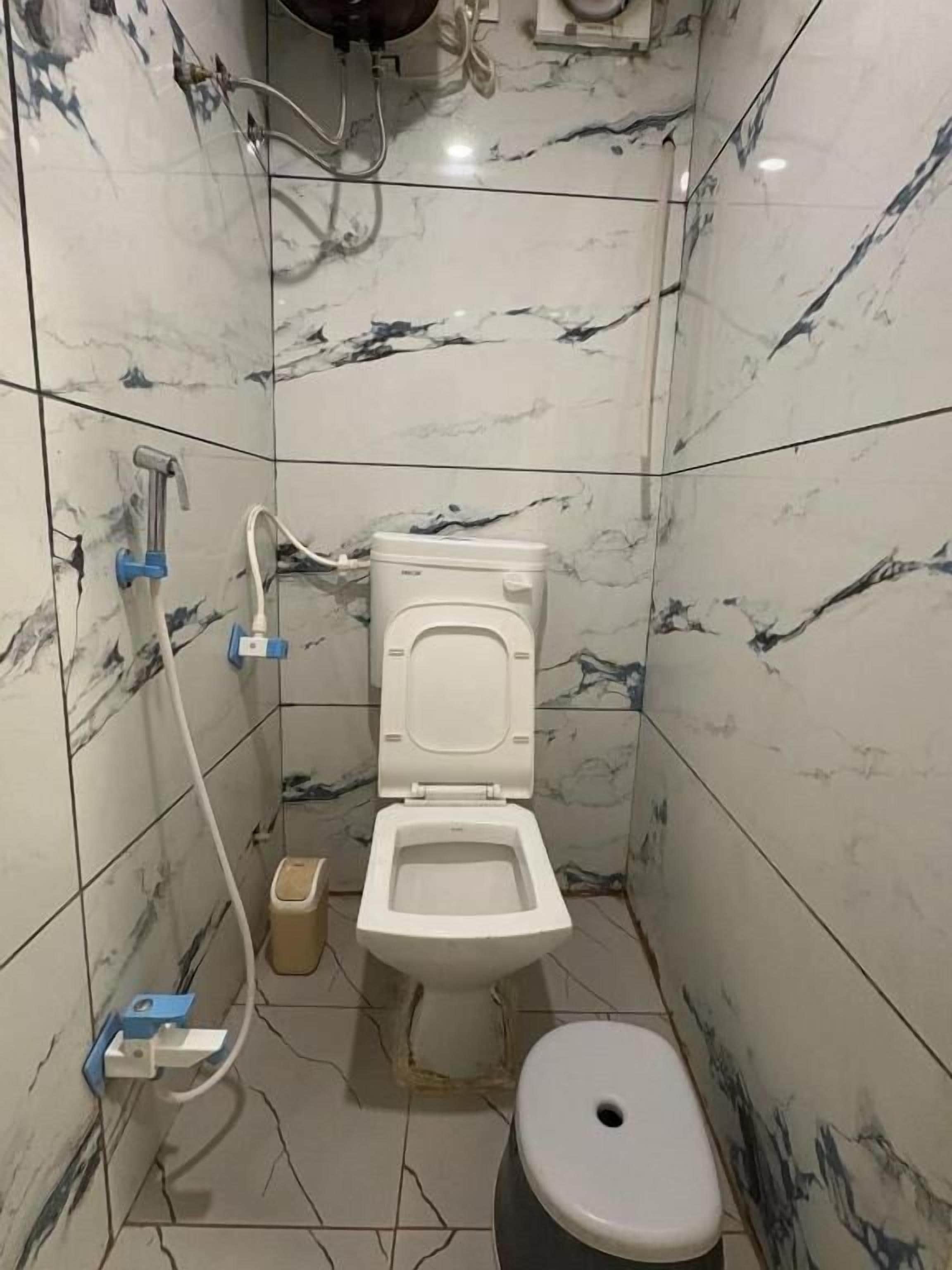 A bathroom with a toilet, bidet, and a trash bin.