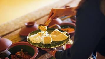 A person serving food from a green plate.