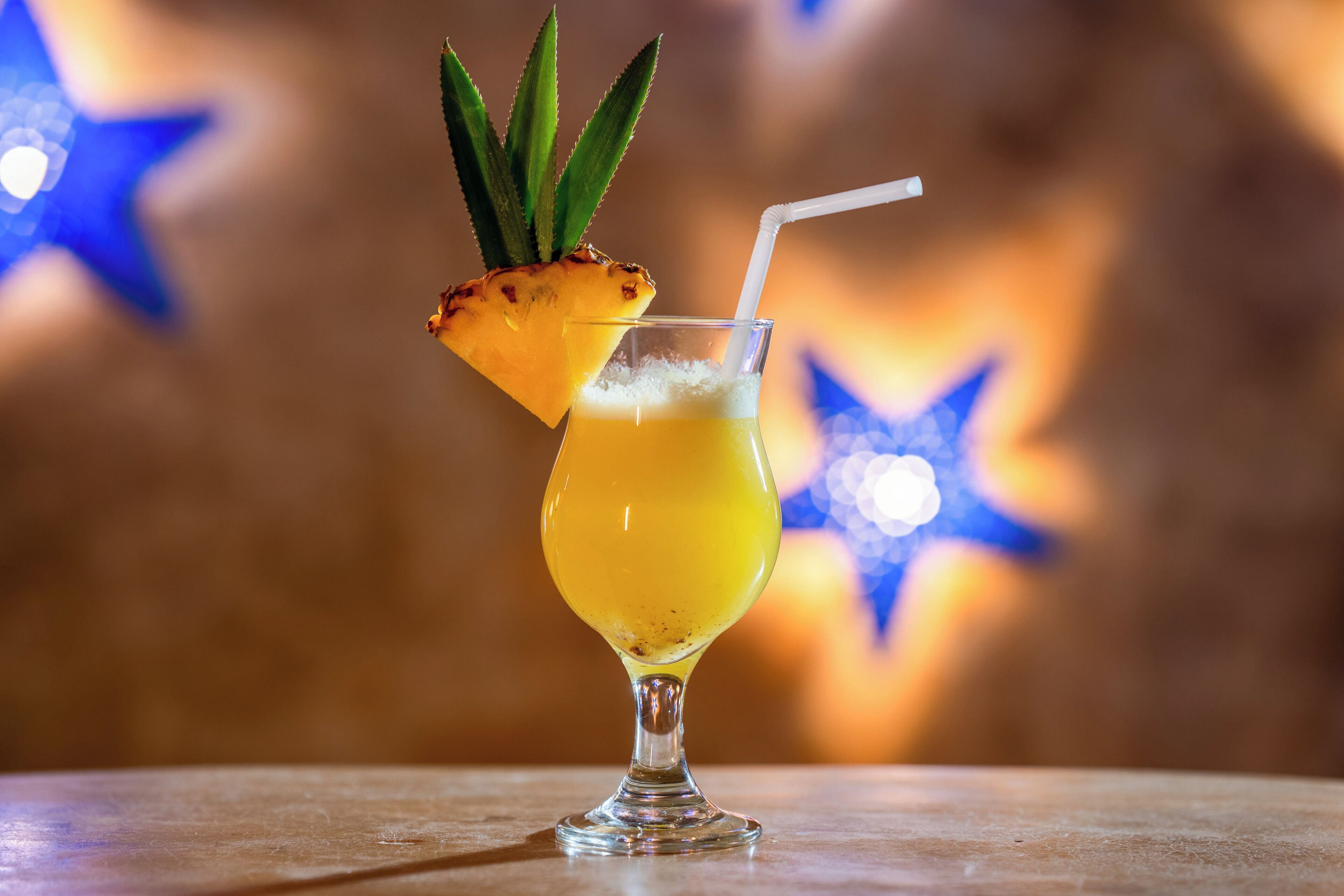 Cóctel con piña y pajita en un vaso.