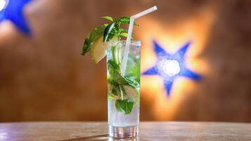 A tall glass with a straw, mint leaves, and a slice of lime.