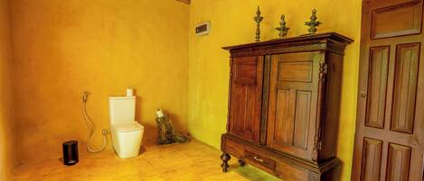 Ein Zimmer mit einem Holzkabinent, einer weißen Toilette und einer Dusche.