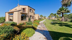 A two-story house with a stone pathway leading to the entrance. - Villa Athena with private pool - My Rental Homes (Castelvetrano)