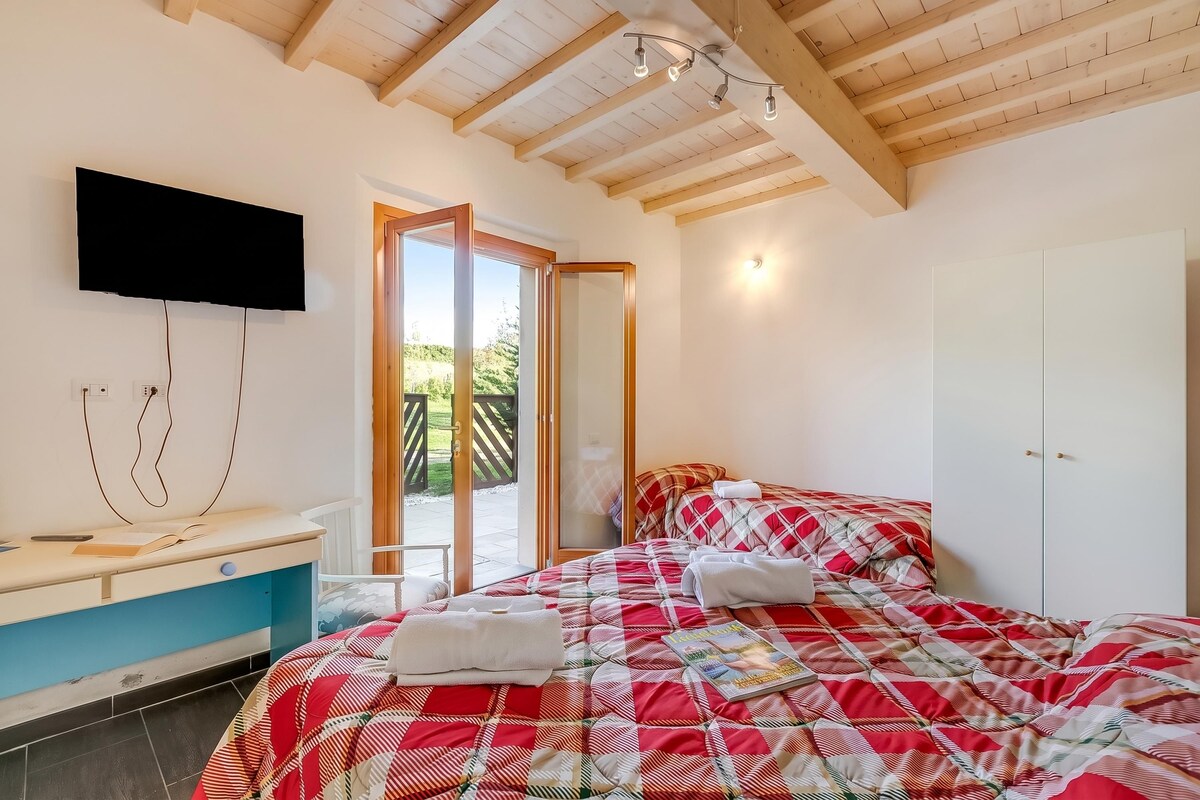 A bedroom with a bed, a desk, a TV, and a wardrobe.