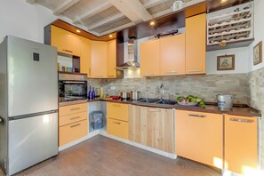 A modern kitchen with a stainless steel refrigerator, wooden cabinets, and a wine rack. - Mugello House With Pool (Vicchio)