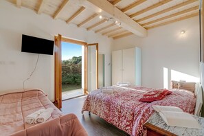 A bedroom with a bed, a TV, a wardrobe, and a door leading to a balcony. - Family & Pet Home Margherita Pool Mugello 6 (Vicchio)