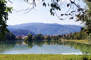 Um lago refletindo edifícios e montanhas ao fundo.