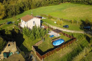 Una casa con piscina, patio cercado y pequeño jardín.