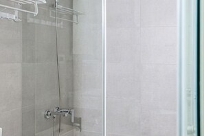 A glass shower enclosure with a chrome faucet and a towel rack. - White Space Design Hotel (Taipei)