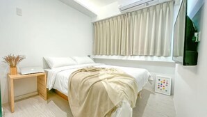 A bedroom with a bed, bedside table, lamp, and window with curtains. - White Space Design Hotel (Taipei)