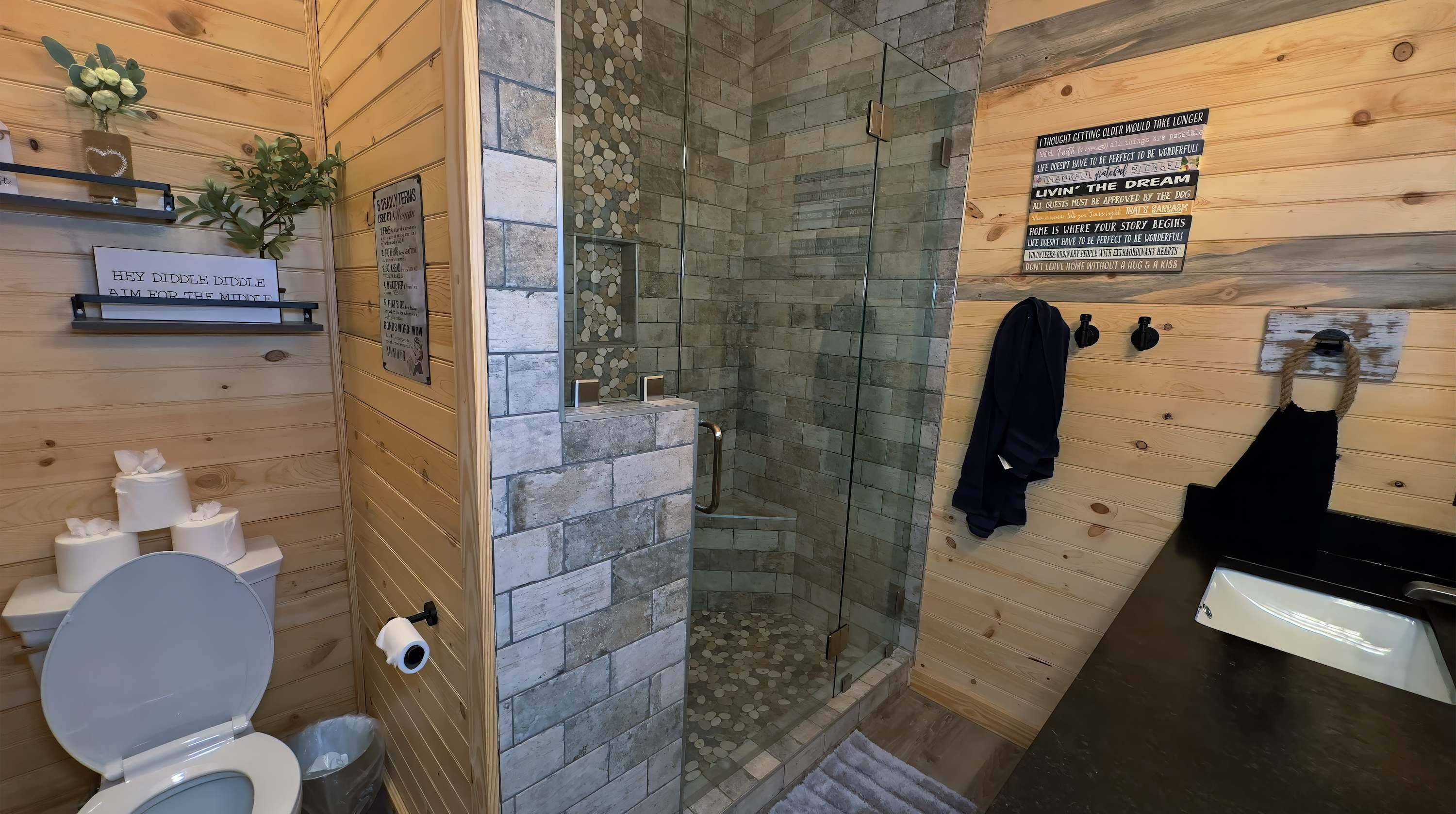 A bathroom with a toilet, a shower with glass walls, and a towel rack.