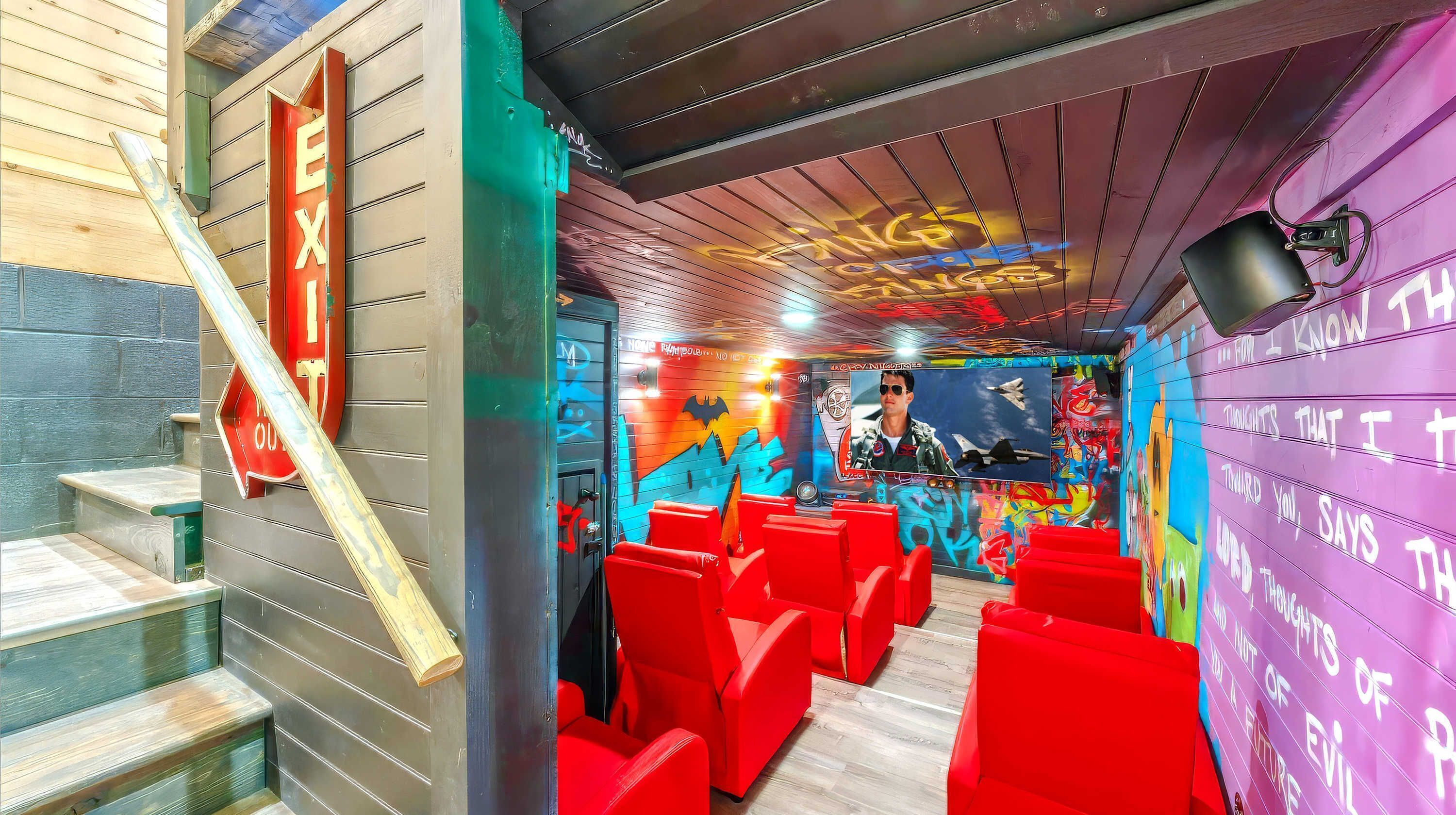 Ein Zimmer mit roten Stühlen, einer Treppe und Graffiti an den Wänden.