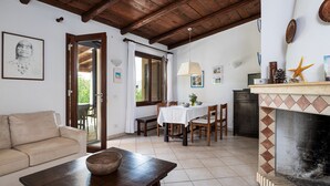 Ein gemütliches Wohnzimmer mit Sofa, Esstisch und Kamin.