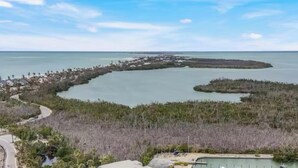 An aerial view of a coastal resort with a marina, swimming pool, and beachfront property. - Charming bayside condo in south seas resort Captiva for a relaxing getaway (Captiva)