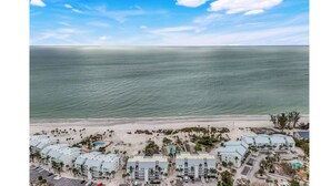 An aerial view of a coastal hotel with multiple buildings, a beach, and a clear sky. - Charming bayside condo in south seas resort Captiva for a relaxing getaway (Captiva)