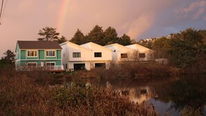 A row of houses by a lake with a rainbow in the sky. - Lakeview Home steps away Twin Rocks Beach Access (Rockaway Beach)