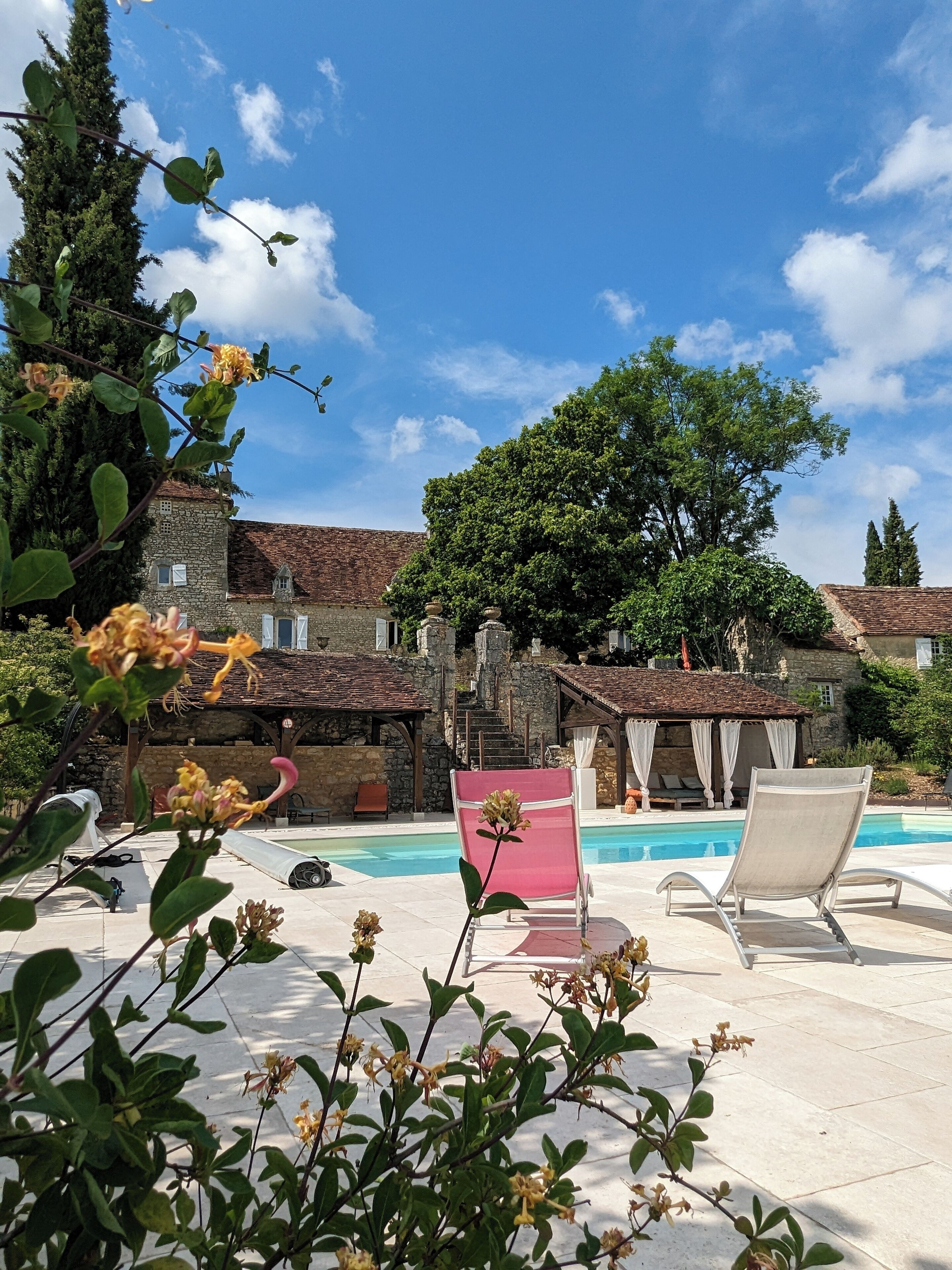 Una piscina al aire libre, sombrillas, sillones reclinables de piscina