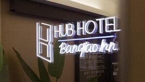 A neon sign for 'HUB HOTEL Bangkok' with a modern design.
