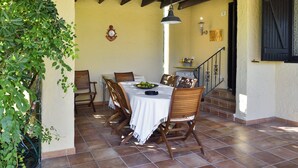 Uma área de refeições com uma mesa, cadeiras, um relógio e uma escada.